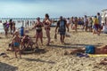 Fish seller walks between different people relaxing on the beach of the city of Anapa