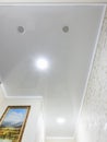 Anapa, Russia - June 25, 2020: Stretch glossy ceiling with spotlights and ventilation outlets in a long small corridor