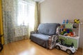 Anapa, Russia - March 1, 2021: Interior of a small modest children`s room with a sofa and toys