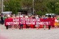 Anapa, Russia - May 9, 2019: Young people in folk costumes carry a sign