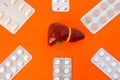 Anatomical models of liver surrounded by six blister packs with white pills inside six-pointed star in corners of image on orange