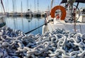 Anchor chain pile closeup, yachts and marina background Royalty Free Stock Photo