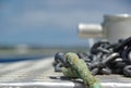 Anchor chain and rope on the front of boat with anchoring point in the background Royalty Free Stock Photo