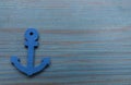 Anchor figure on light blue wooden table, top view. Space for text