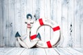 Anchor and life buoy on a background of white wall. Royalty Free Stock Photo