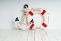 Anchor and life buoy on a white wooden floor