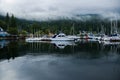 The anchor yacht in harbor After rain cloudy sky, misty forest mountains and calm water.