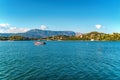 Anchored boat on sea surface against Corfu under blue sky