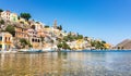 Anchored boats and colorful neoclassical houses in bay of Symi Symi Island, Greece