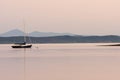 Anchored sailboat on a lake with mountains in the background at sunset Royalty Free Stock Photo