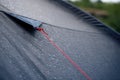 Anchoring red rope on tent with drops of rain