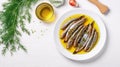 Anchovies marinated in olive oil and cooked at low temperature on a white plate. Royalty Free Stock Photo