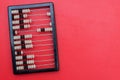 Ancient abacus with knuckles on a red background