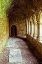 Ancient abby vaulted walkway with pillars open to courtyard Royalty Free Stock Photo