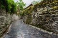 Ancient alley with stone-stacked walls in cloudy spring afternoon