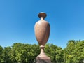 Ancient amphora of marble against the blue sky and trees Royalty Free Stock Photo