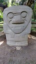 An ancient anthropo-zoomorphic sculpture with triangular face and monkey features at Colombian San Agustin archaeological park