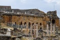 Ancient antique amphitheater in city of Hierapolis in Turkey. Side view. Steps and antique statues with columns in the