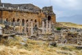Ancient antique amphitheater in city of Hierapolis in Turkey. Side view. Steps and antique statues with columns in the