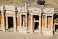 Ancient antique amphitheater in city of Hierapolis in Turkey. Steps and antique statues with columns in the amphitheater Royalty Free Stock Photo