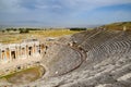 Ancient antique amphitheater in city of Hierapolis in Turkey. Steps and antique statues with columns in the amphitheater Royalty Free Stock Photo