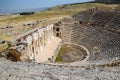 Ancient antique amphitheater in city of Hierapolis in Turkey. Steps and antique statues with columns in the amphitheater Royalty Free Stock Photo