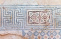 Ancient, antique mosaic of small colored tiles with geometric pa