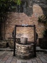 Ancient artesian well with hanging wood bucket and wooden roof Royalty Free Stock Photo