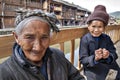 Ancient Asian Peasant woman resting on bench in Chinese countryside.