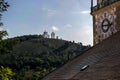 An ancient astronomical clock overlooking the opposite hill with a white chapel Royalty Free Stock Photo