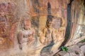 Ancient bas-relief of 3 people dressed Khmer costumes or Hindu Gods and Goddess at Pha Mo I Daeng cliff