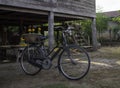 Ancient bikes are placed near traditional Thai wooden houses in the northeast of Thailand