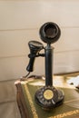 Ancient black candlestick telephone vintage analog dialing or scrolling phone on wooden table interior for home and living Royalty Free Stock Photo