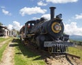 An ancient black and yellow locomotive with red wagon