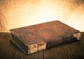 Ancient book on the old wooden table. Toned Royalty Free Stock Photo