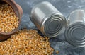 An ancient bowl full of uncooked popcorn seeds with metallic cans