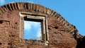 Ancient brick wall with arched top and window with marble profiles, blue sky Royalty Free Stock Photo