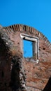 Ancient brick wall with arched top and window with marble profiles, blue sky Royalty Free Stock Photo
