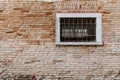 Ancient brick wall texture. Window with grill and railings Royalty Free Stock Photo