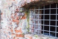 Ancient brick wall and window locked with metal bars Royalty Free Stock Photo