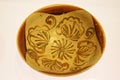 An ancient brown bowl with grass and flower figure