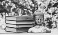 Ancient Buddha statue and a stack of books. Religion and culture.