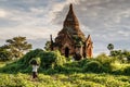 Ancient Buddhist pagoda in the old city of Bagan, the world heritage site. Myanmar Burma. A local worker on the road.