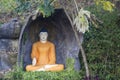 Ancient buddhist sculpture of buddha in orange clothes
