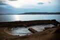 Ancient building foundation in sea water on blue sky background