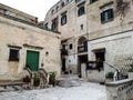 Ancient buildings with green shutters and doors to the city of Matera
