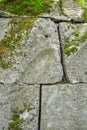 Ancient, built of weathered stone blocks. Masonry, overgrown with green moss Royalty Free Stock Photo