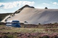 Ancient bus chugging through dune landscape Royalty Free Stock Photo