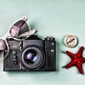 Ancient camera, compass and sea souvenirs on a blue background.