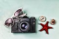 Ancient camera, compass and sea souvenirs on a blue background.